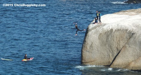 2 Four Cape Town Girls in Wetsuits jumping off Sunset Rocks
