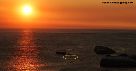 4 Canoeist (highlighted) paddling past Sunset Rocks at Sunset